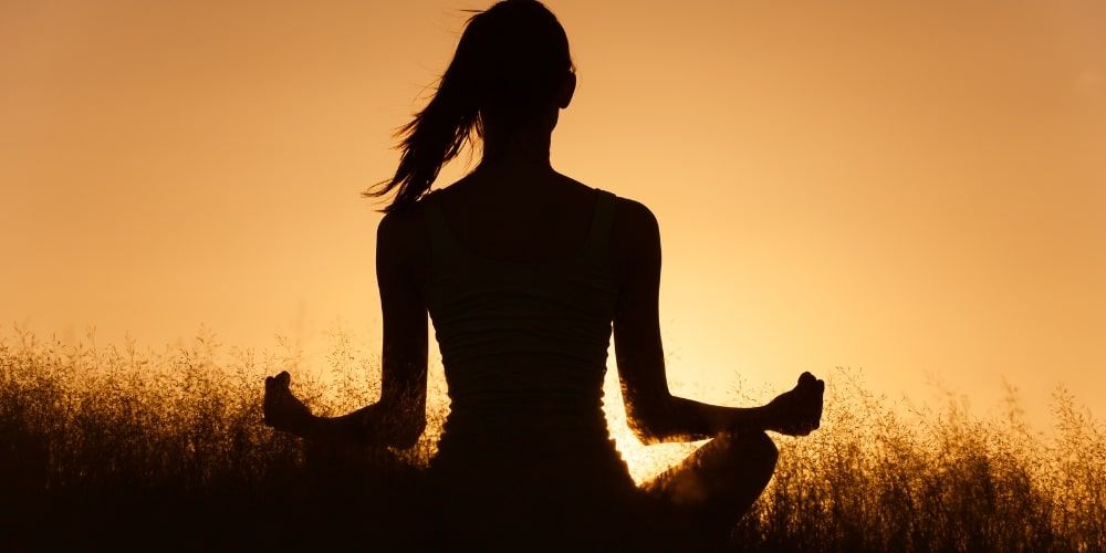 Donna in meditazione al tramonto a Laghi Nabi, wellness resort in Campania Donna in meditazione al tramonto a Laghi Nabi, wellness resort in Campania