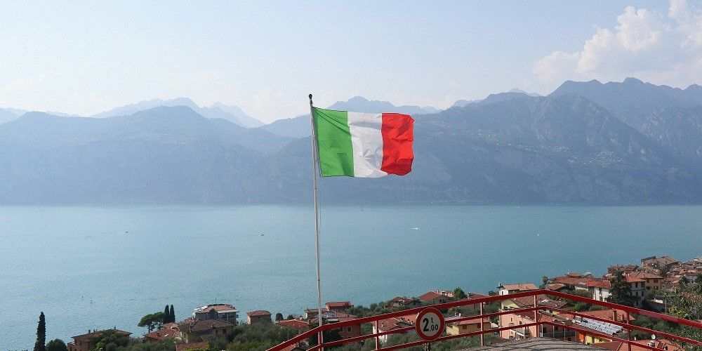 An Italian flag flutters over the sea